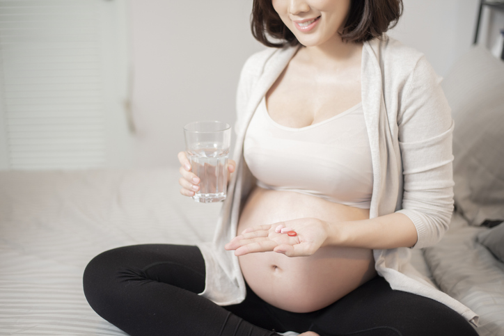 vitaminas prenatales en manos de mujer embarazada